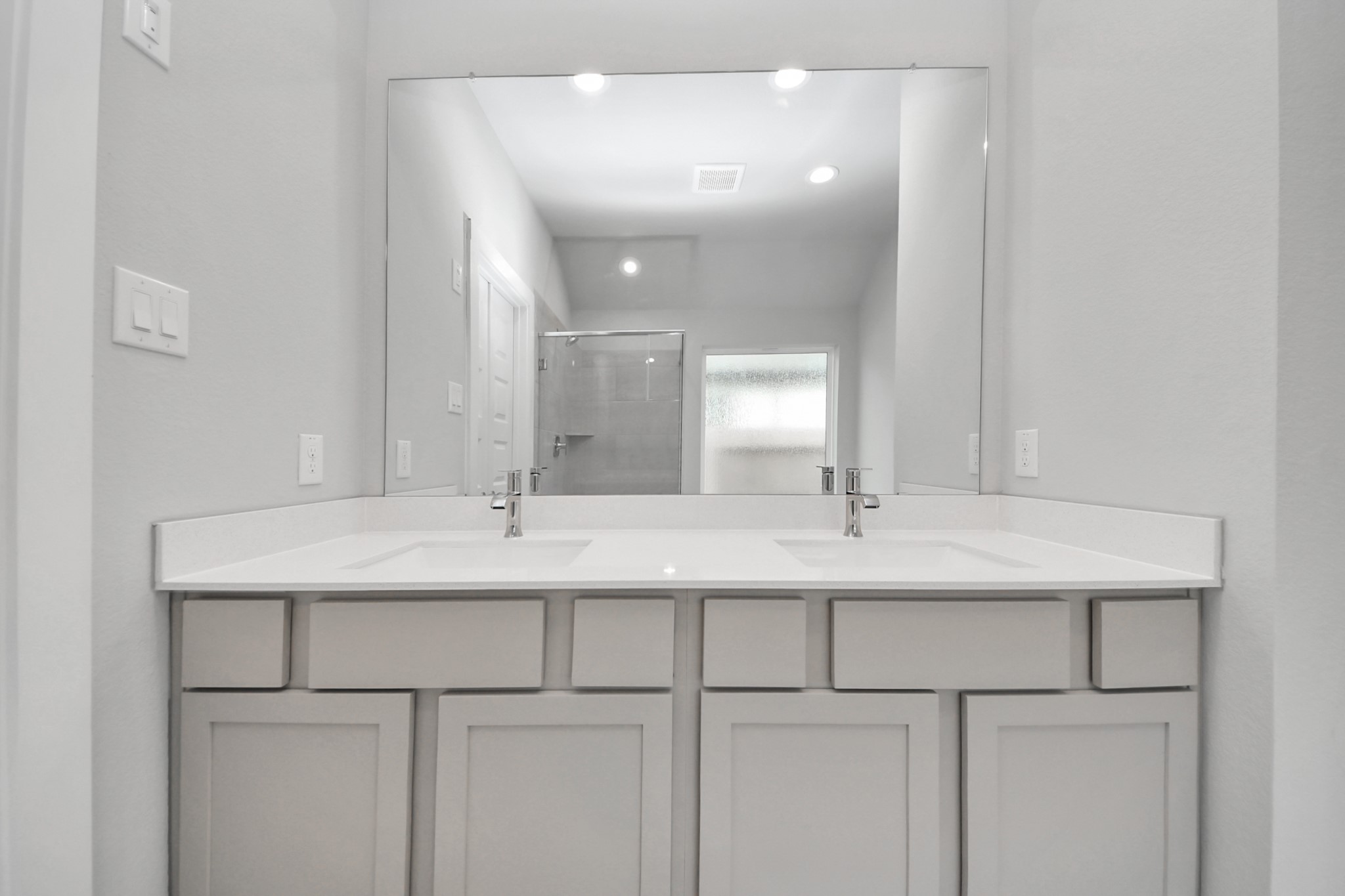 24518 Broad Park Spring, TX 77373 - Photo 25 of 29 Elevate your daily routine at the elegant vanity, now equipped with double sinks, light countertops, modern hardware, and beautiful recessed lights. Sample photo of completed home with similar floor plan. Actual colors and selections may vary.