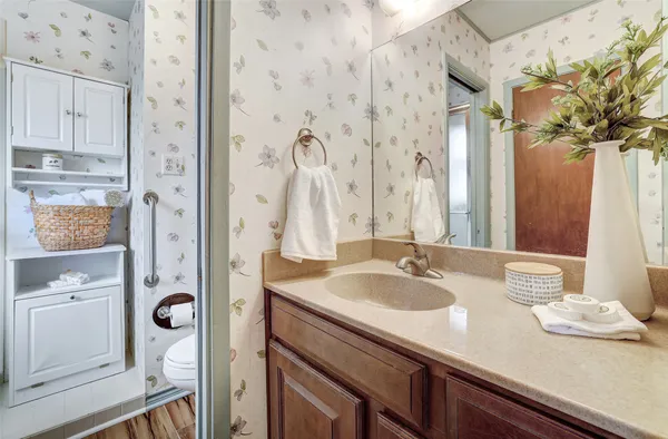 a bathroom with a granite countertop sink a mirror a vanity and a shower