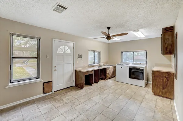 a large white kitchen with cabinets