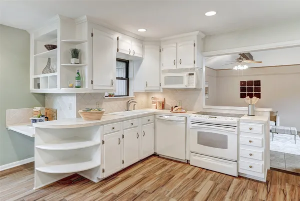 a kitchen with granite countertop white cabinets and white appliances