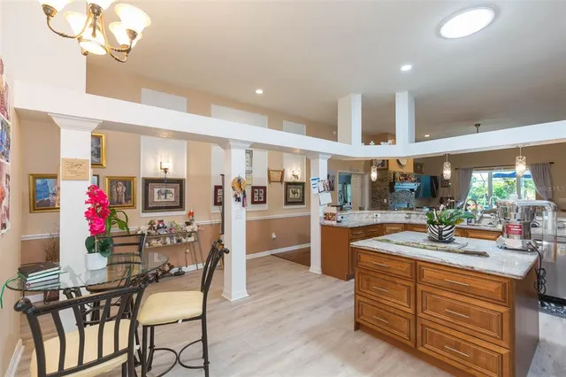 a kitchen with a dining table chairs and wooden floor
