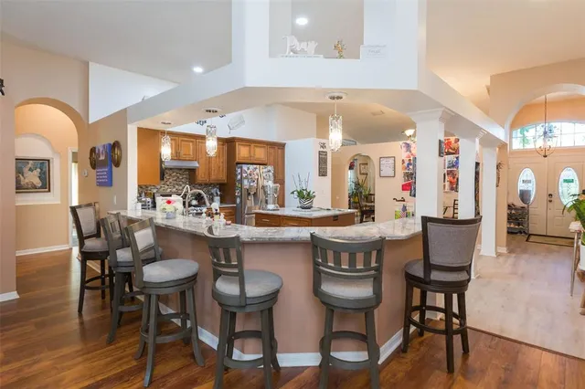 a living room with furniture kitchen view and a potted plant