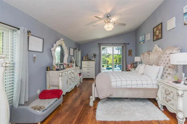 a bedroom with a bed a chandelier and dresser