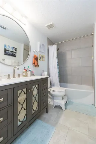 a bedroom with a bed and a flat tv screen on dresser