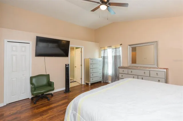 a bedroom with a bed and a flat tv screen on dresser