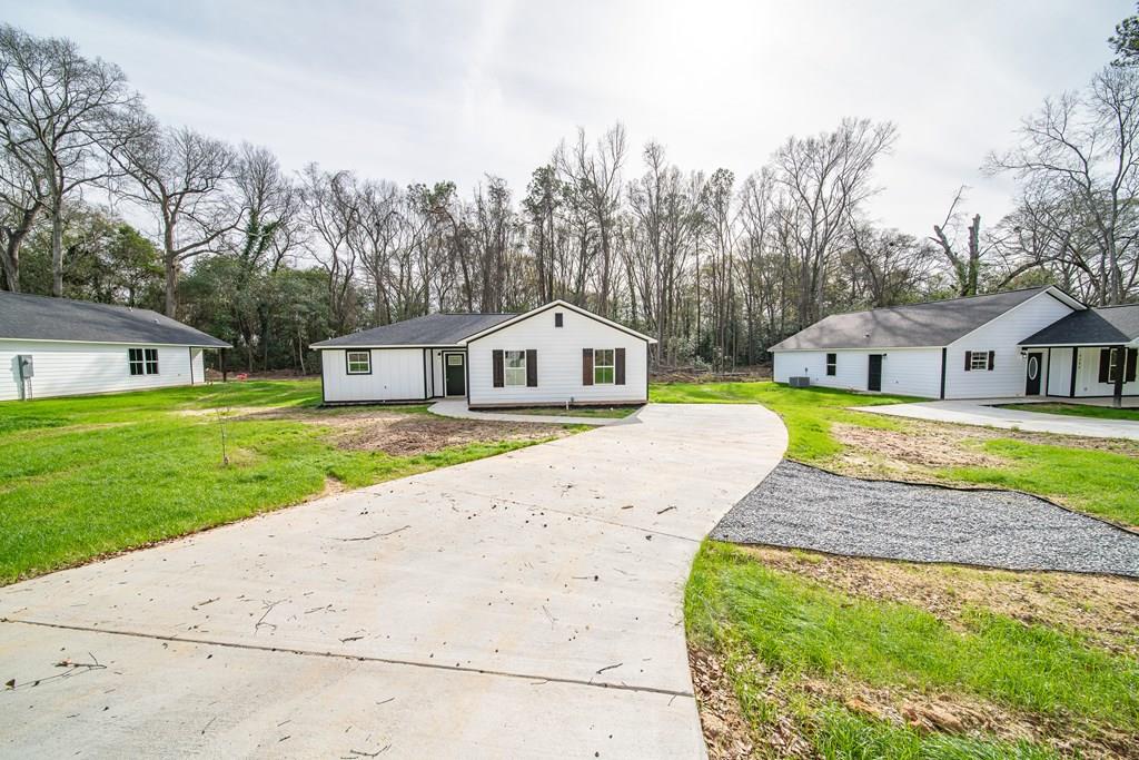 a view of house with garden and tall trees