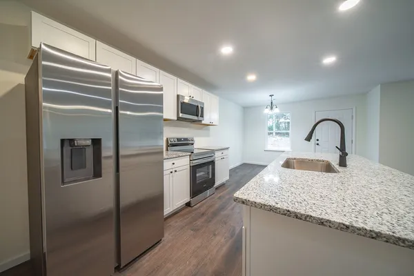 a kitchen with stainless steel appliances granite countertop a sink stove and refrigerator
