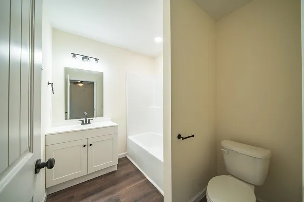 a bathroom with a toilet a sink and mirror