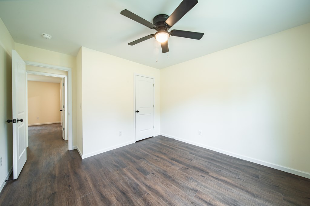 4390 Forrest Road Columbus, GA 31907 - Photo 24 of 26 an empty room with wooden floor and a ceiling fan