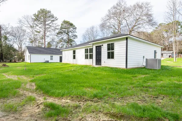 a front view of house with yard and trees all around