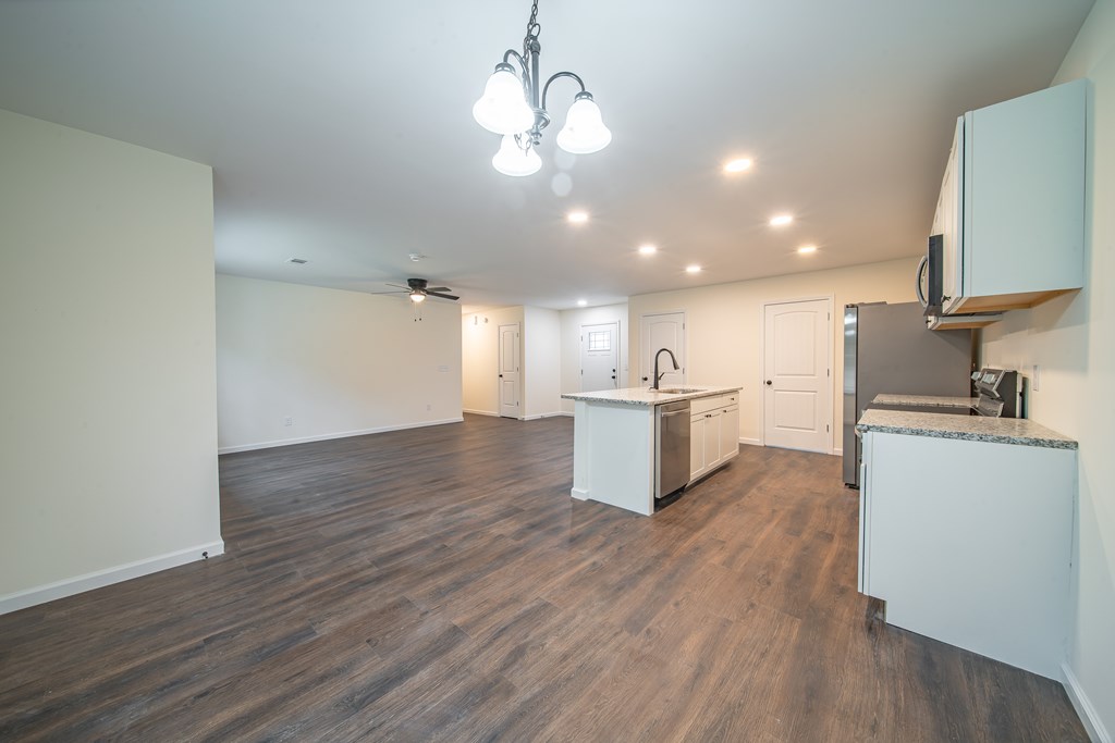 4390 Forrest Road Columbus, GA 31907 - Photo 7 of 26 a view of a kitchen with a sink and dishwasher a refrigerator with wooden floor