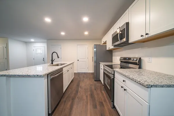 a large kitchen with a stove and a sink