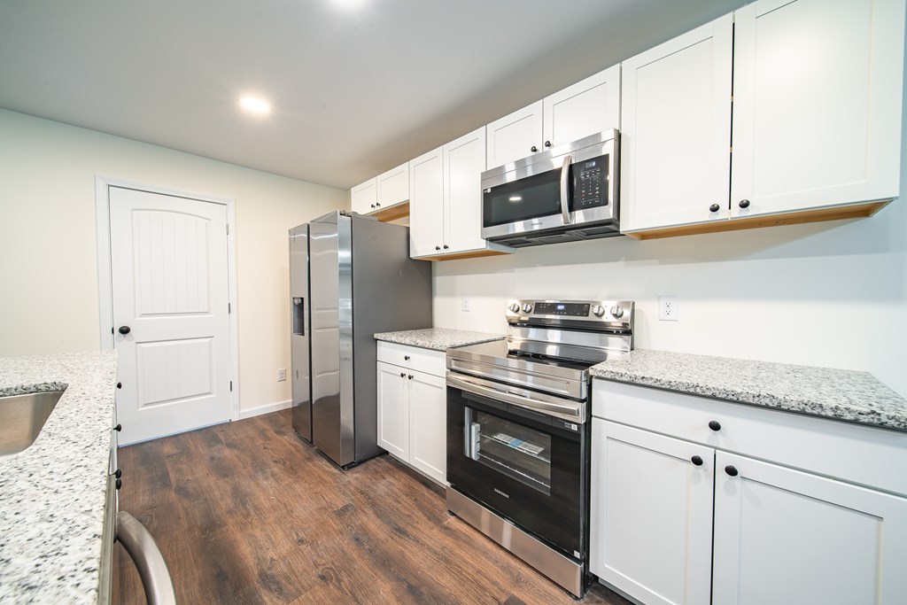 4390 Forrest Road Columbus, GA 31907 - Photo 9 of 26 a kitchen with stainless steel appliances granite countertop a stove a microwave and a refrigerator