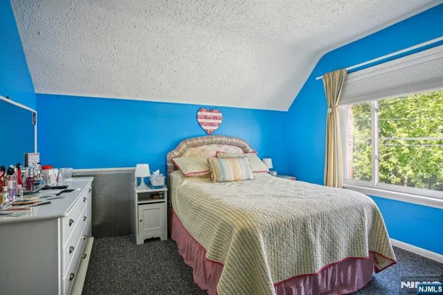 a bedroom with a bed a potted plant and a large mirror