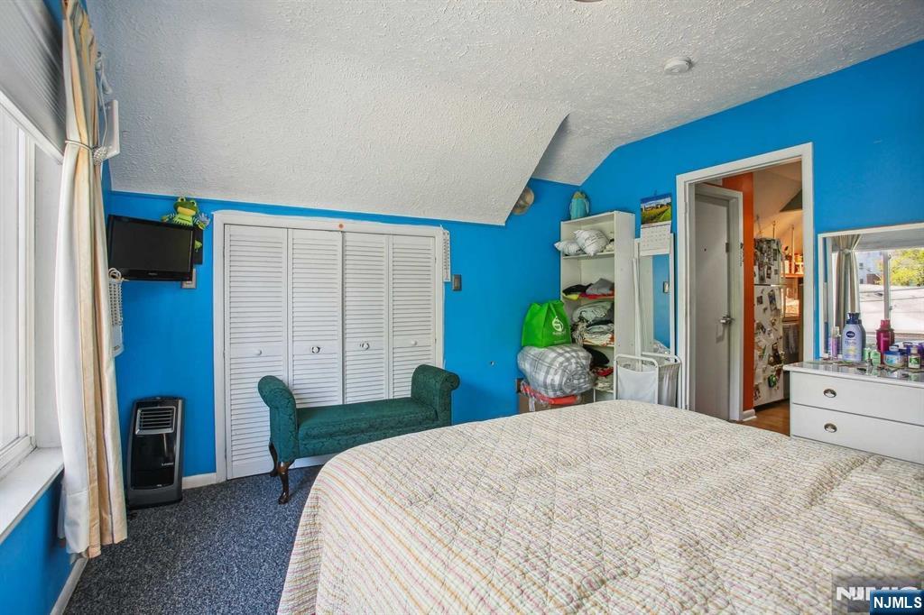 16 Henry Street, Unit 3 Bloomfield, NJ 07003 - Photo 15 of 21 a bedroom with a bed a potted plant and a large mirror