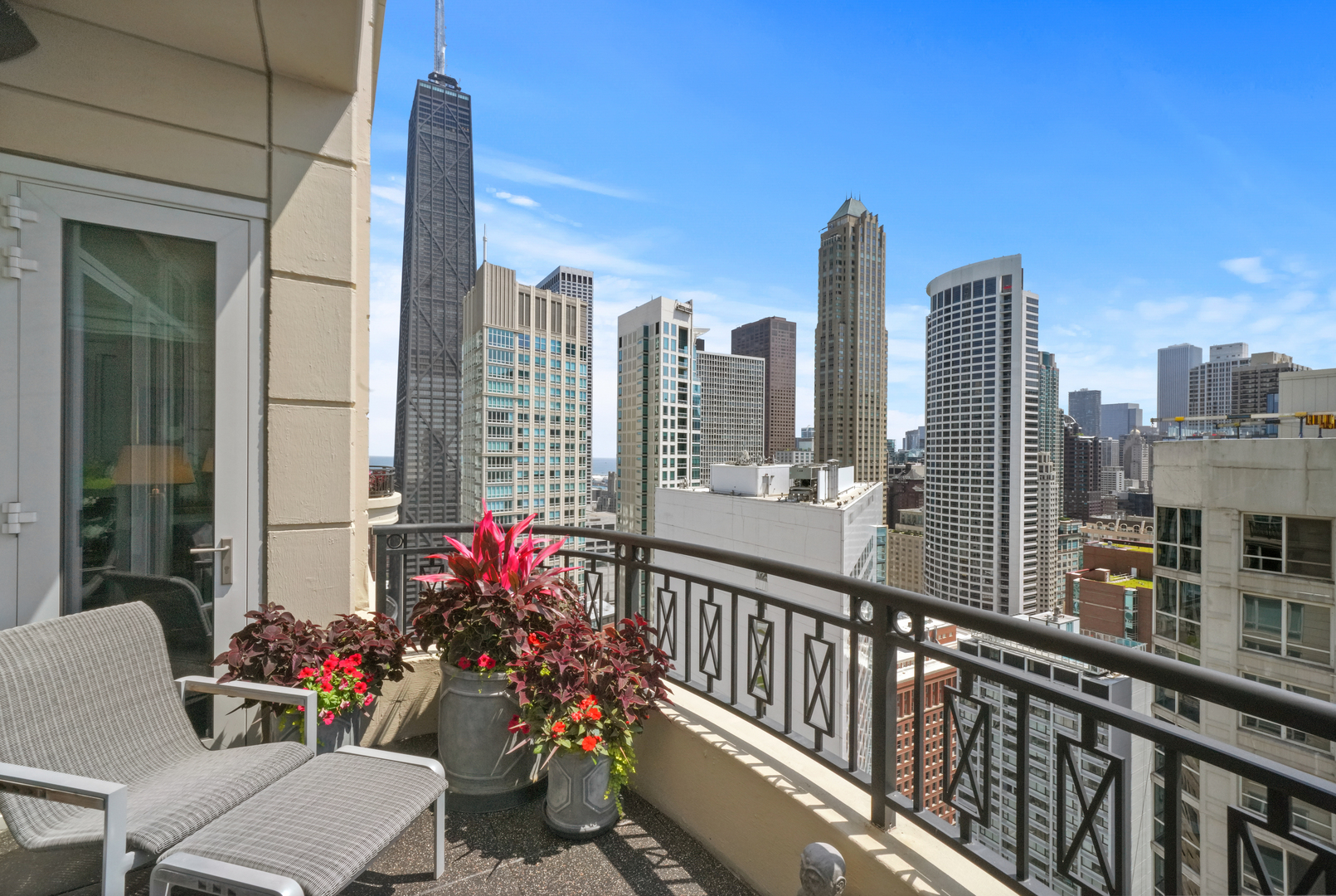 10 East Delaware Place, Unit 34A Chicago, IL 60611 - Photo 20 of 51 a view of a balcony with wooden benches and a potted plant