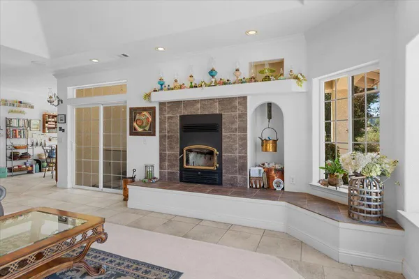 a large living room with stainless steel appliances furniture a rug and a large window