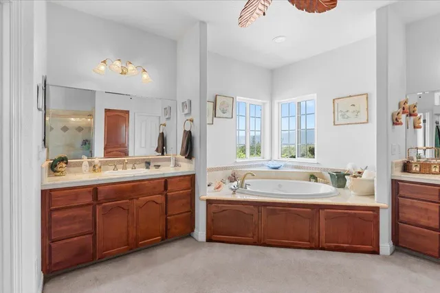 a spacious bathroom with a double vanity sink a large mirror and a bathtub