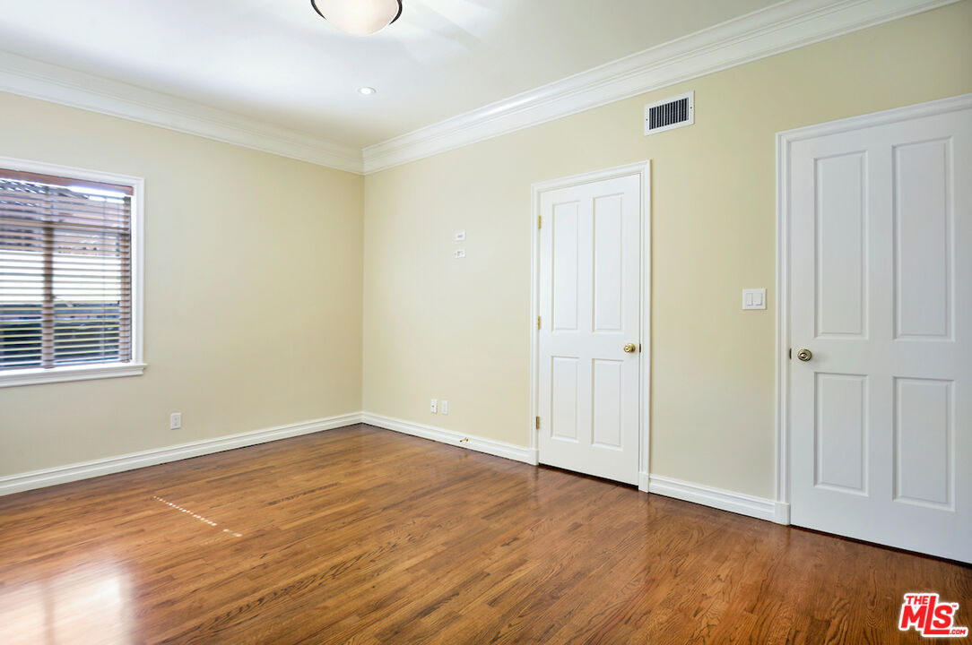 157 South Rodeo Drive Beverly Hills, CA 90212 - Photo 6 of 7 an empty room with wooden floor and closet