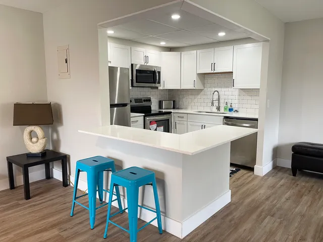 a kitchen with a table chairs microwave and cabinets