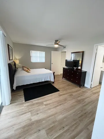 a bedroom with a bed and wooden floor