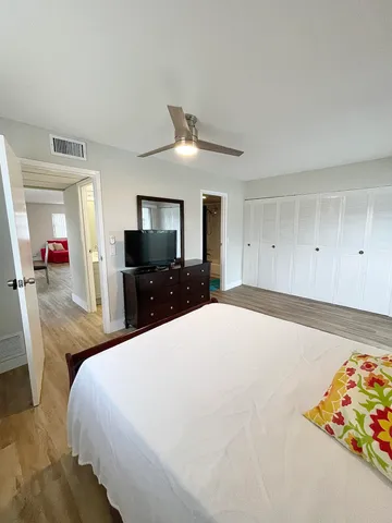 a large bedroom with a bed and a flat screen tv