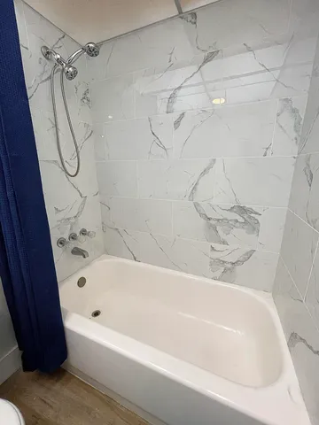 a bathroom with a bath tub with a shower