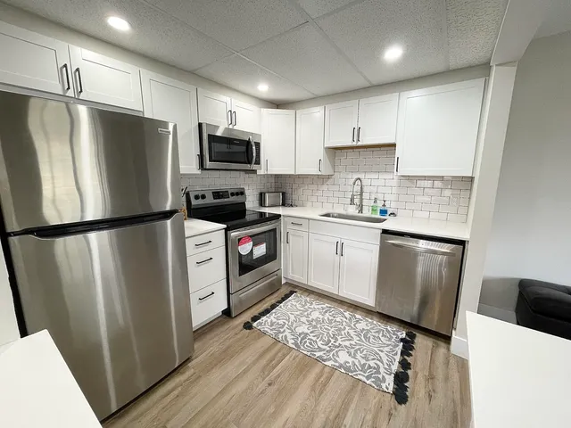 a kitchen with stainless steel appliances a refrigerator sink and microwave
