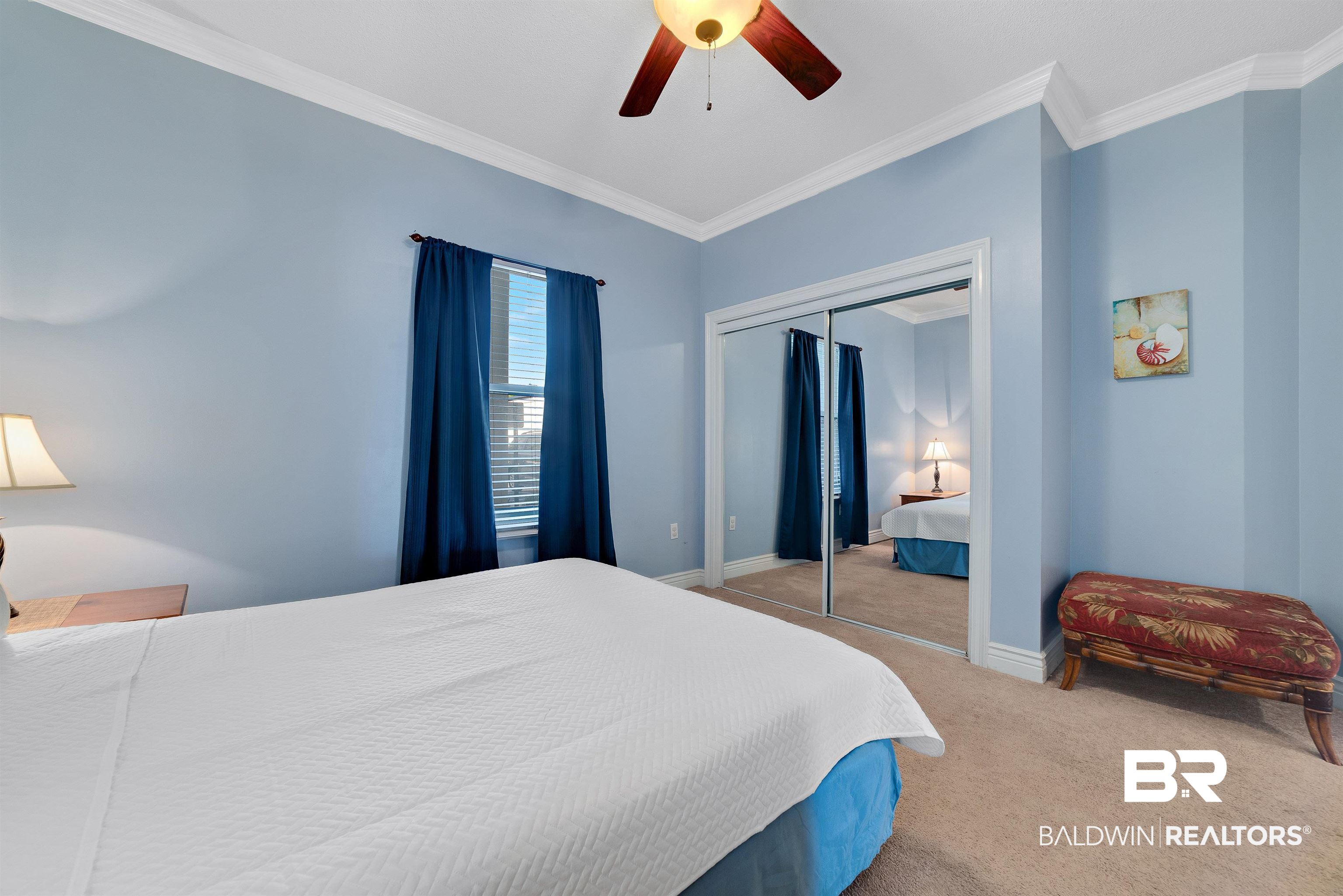 27282 Canal Road, Unit 110 Orange Beach, AL 36561 - Photo 26 of 62 Carpeted bedroom with a ceiling fan, baseboards, ornamental molding, and a closet