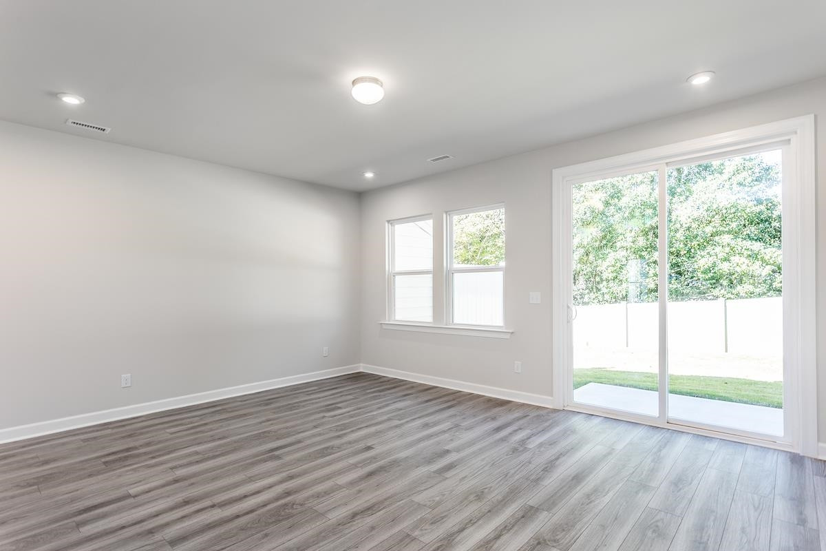 7804 Sofiana Avenue Raleigh, NC 27617 - Photo 11 of 28 an empty room with wooden floor and windows