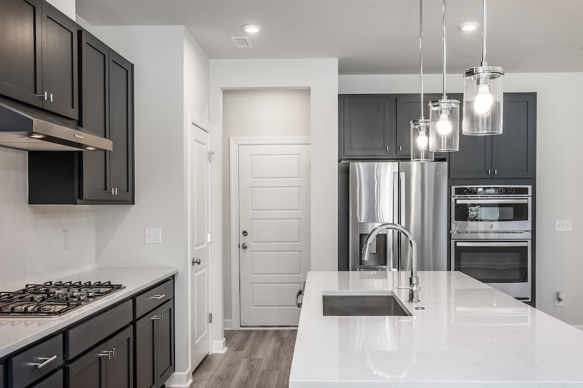 7804 Sofiana Avenue Raleigh, NC 27617 - Photo 12 of 28 a kitchen with kitchen island a counter top space appliances and cabinets