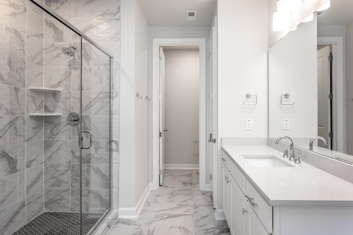 7804 Sofiana Avenue Raleigh, NC 27617 - Photo 16 of 28 a bathroom with a double vanity sink and a mirror