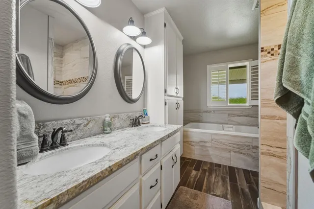 a bathroom with a granite countertop sink and a mirror