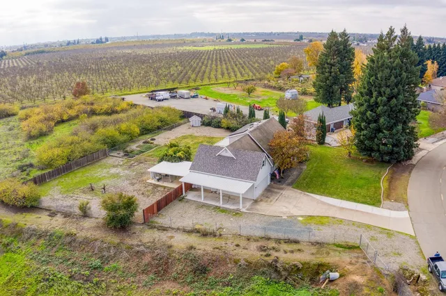 an aerial view of residential houses with outdoor space and lake view