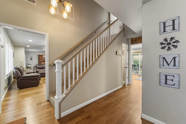 a view of a livingroom with wooden floor and stairs