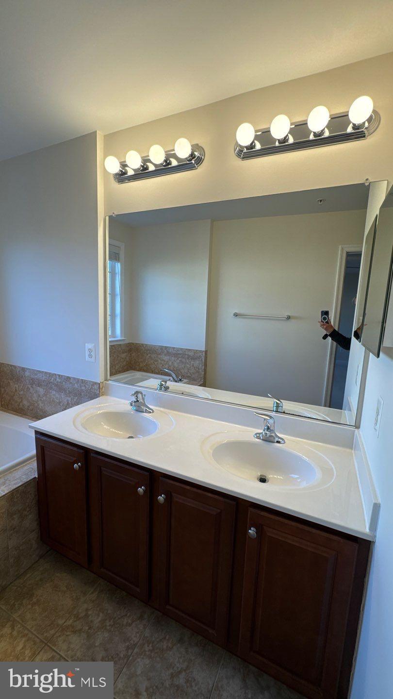 9727 June Flowers Way Laurel, MD 20723 - Photo 17 of 30 a bathroom with a sink and a mirror