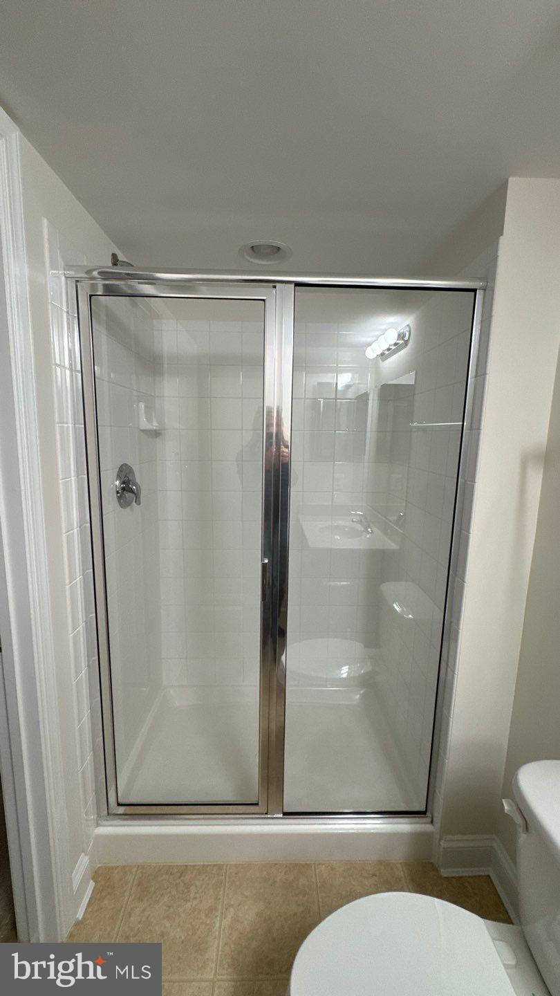 9727 June Flowers Way Laurel, MD 20723 - Photo 29 of 30 a bathroom with a glass shower door