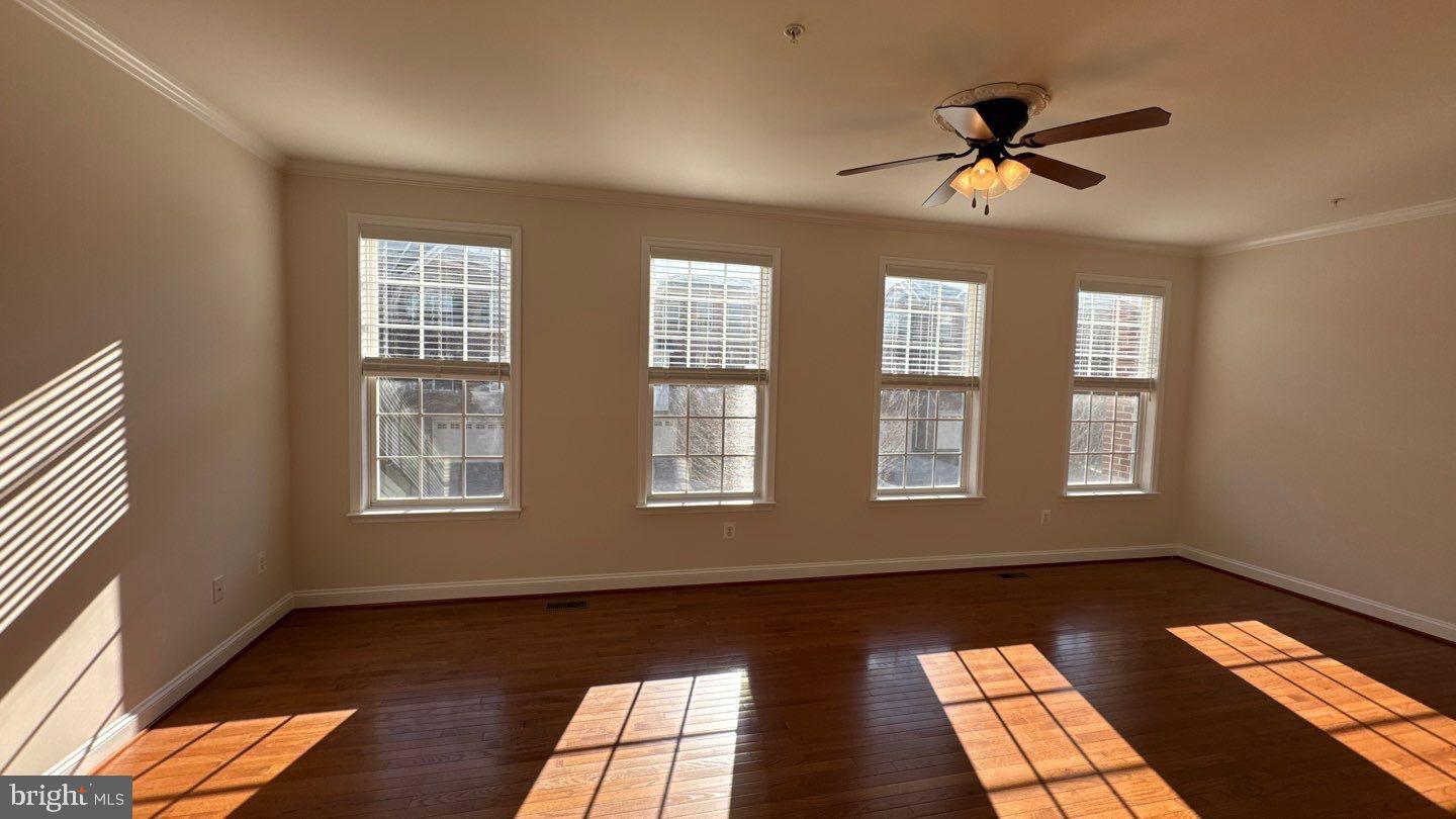 9727 June Flowers Way Laurel, MD 20723 - Photo 4 of 30 a view of an empty room with a window and wooden floor