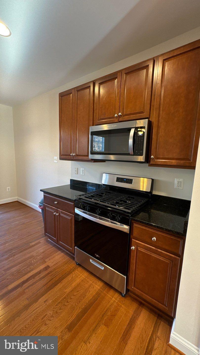 9727 June Flowers Way Laurel, MD 20723 - Photo 7 of 30 a kitchen with wooden cabinets and a stove top oven