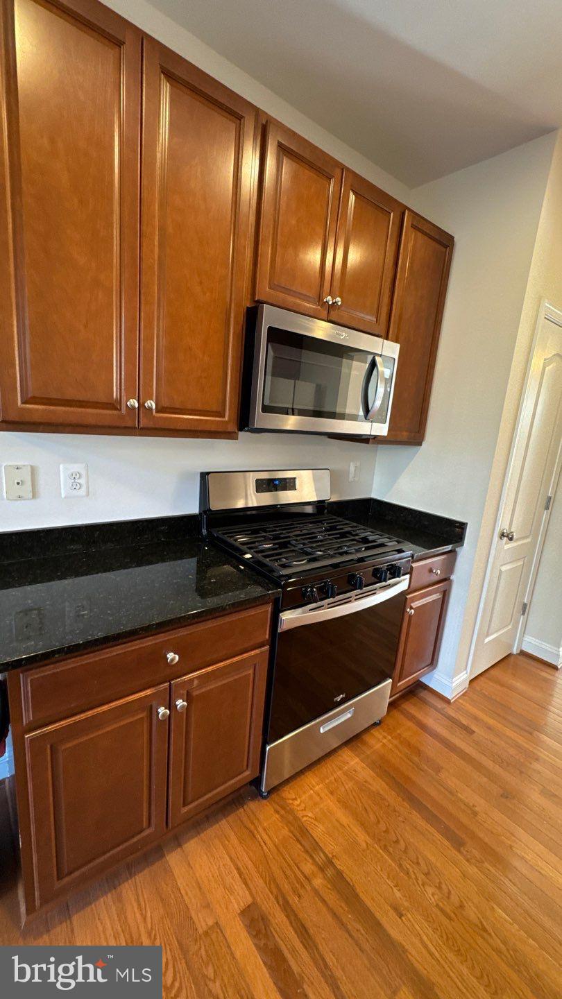9727 June Flowers Way Laurel, MD 20723 - Photo 8 of 30 a kitchen with wooden cabinets and a stove top oven