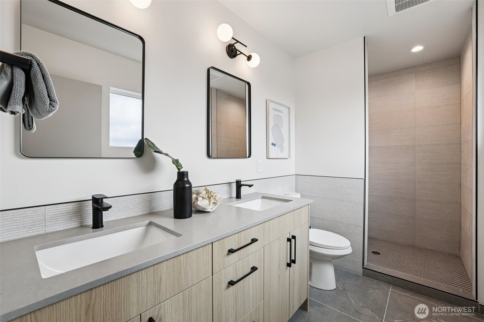 2626 A 58th Avenue Southwest Seattle, WA 98116 - Photo 16 of 40 a bathroom with a double vanity sink toilet and mirror