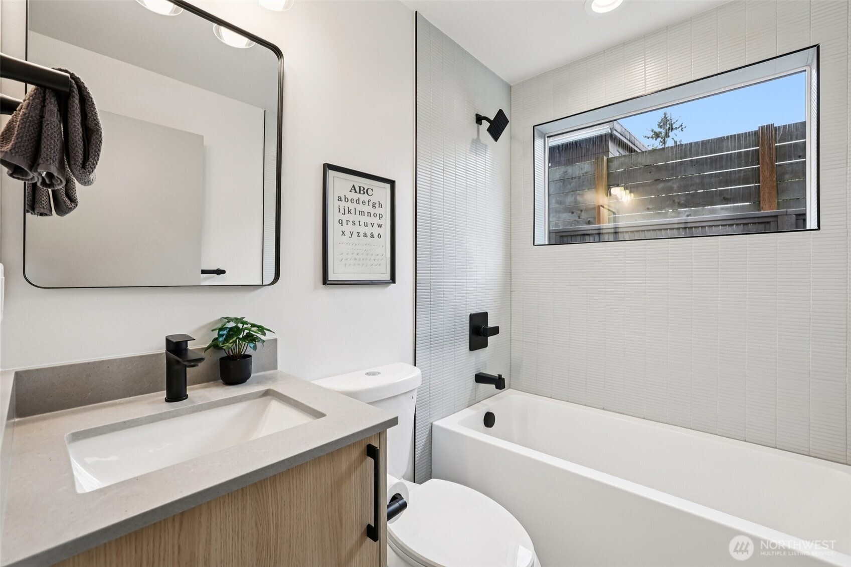 2626 A 58th Avenue Southwest Seattle, WA 98116 - Photo 22 of 40 a bathroom with a sink a mirror a toilet and a bathtub