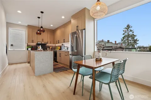 a kitchen with stainless steel appliances kitchen island granite countertop a sink a stove and a wooden floors