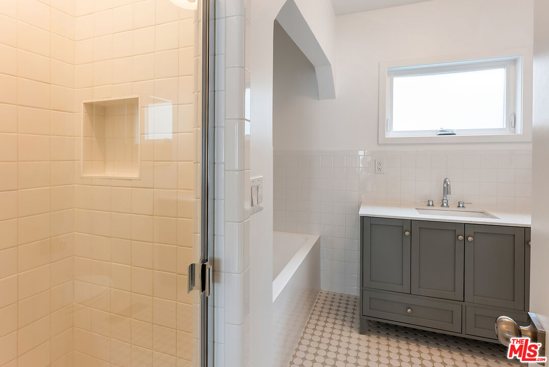 1253 South Rimpau Boulevard Los Angeles, CA 90019 - Photo 64 of 71 a bathroom with a sink a vanity and a mirror