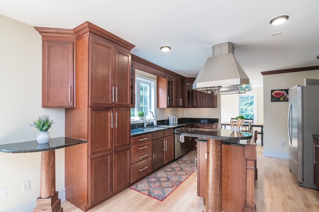 958 East Pleasant Street Amherst, MA 01002 - Photo 11 of 42 a kitchen with granite countertop a sink stainless steel appliances wooden floor and cabinets