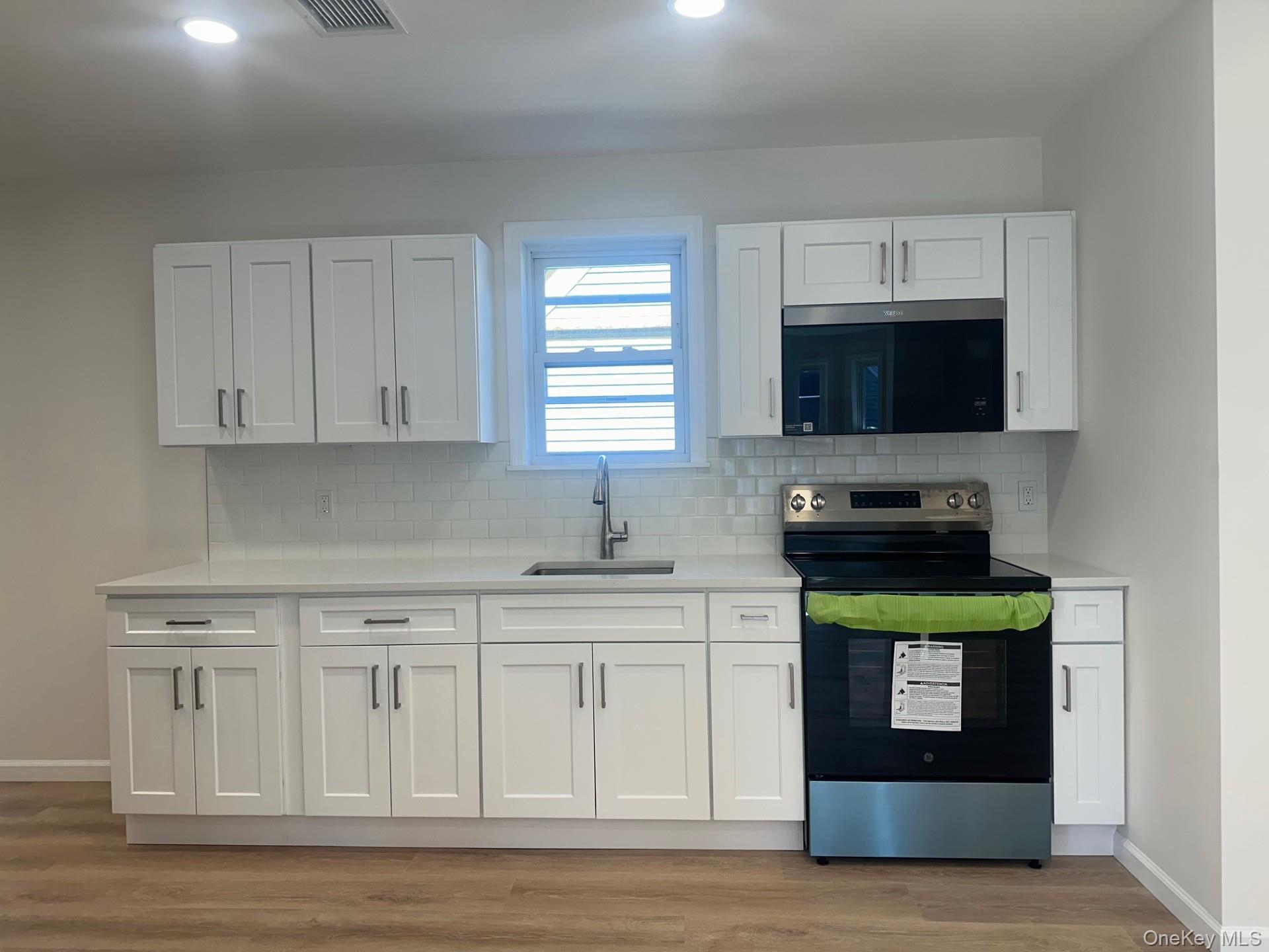 38 Carroll Street, Unit 2 Poughkeepsie, NY 12601 - Photo 3 of 8 a kitchen with stainless steel appliances granite countertop a stove a sink and a microwave