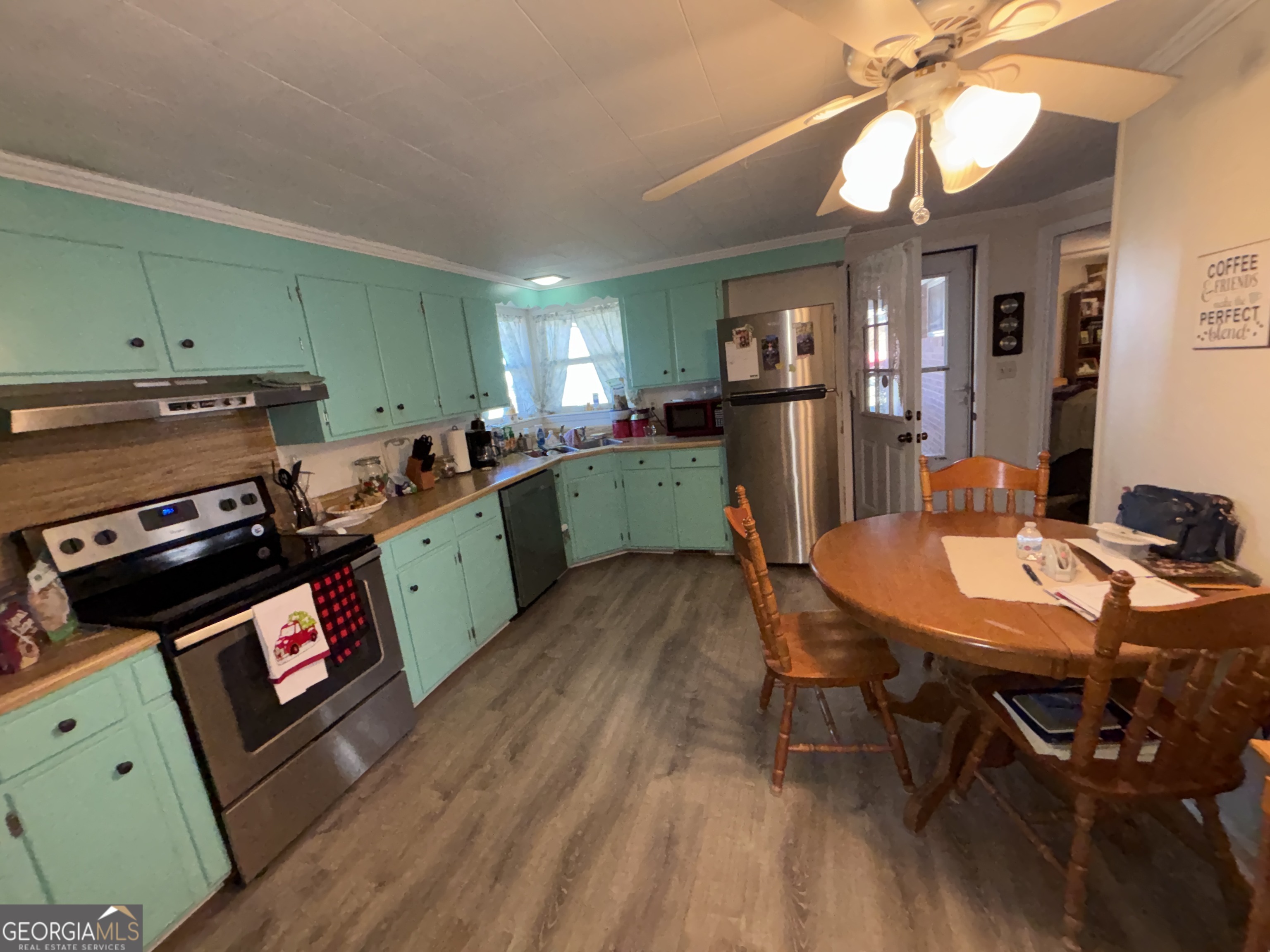 216 East Peter Street Cochran, GA 31014 - Photo 12 of 44 a kitchen with a dining table chairs and a stove