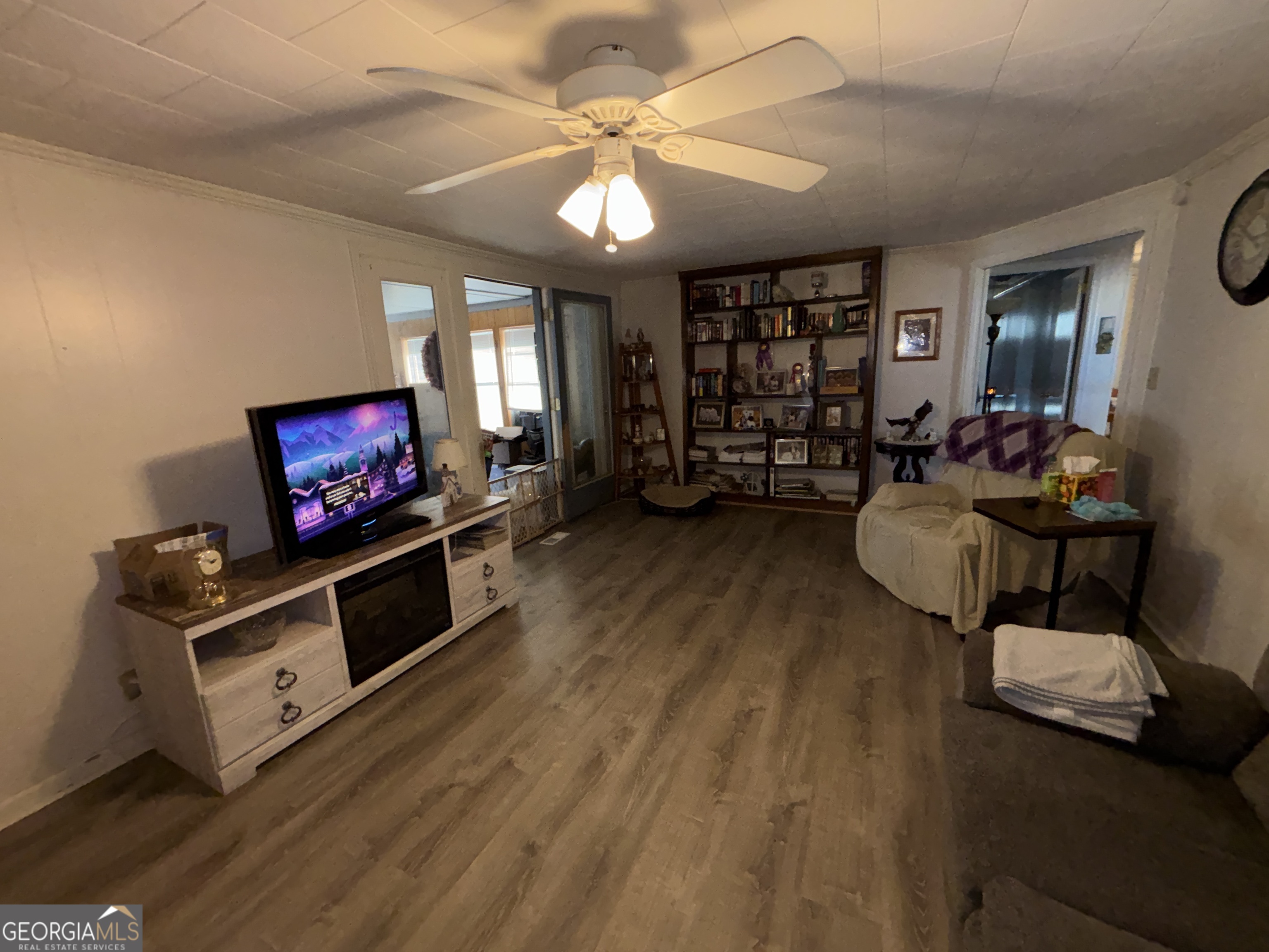 216 East Peter Street Cochran, GA 31014 - Photo 20 of 44 a living room with furniture a flat screen tv and a bookshelf