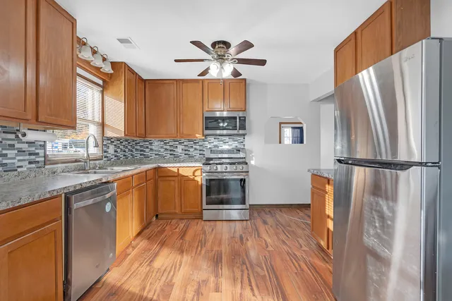 a kitchen with stainless steel appliances a refrigerator sink and microwave