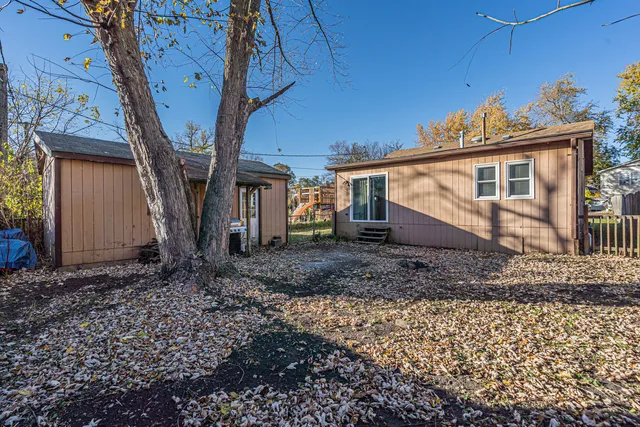 a view of a house with a yard and hanging chair